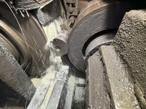 Centerless in-feed grinding of a cylindrical part with coolant flowing